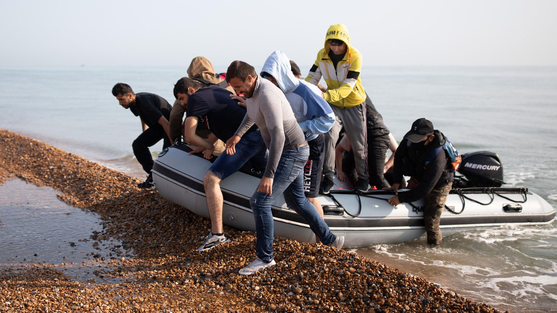 Migrants land on Deal beach last month after crossing the English channel from France in a dinghy - Credit: Getty Images