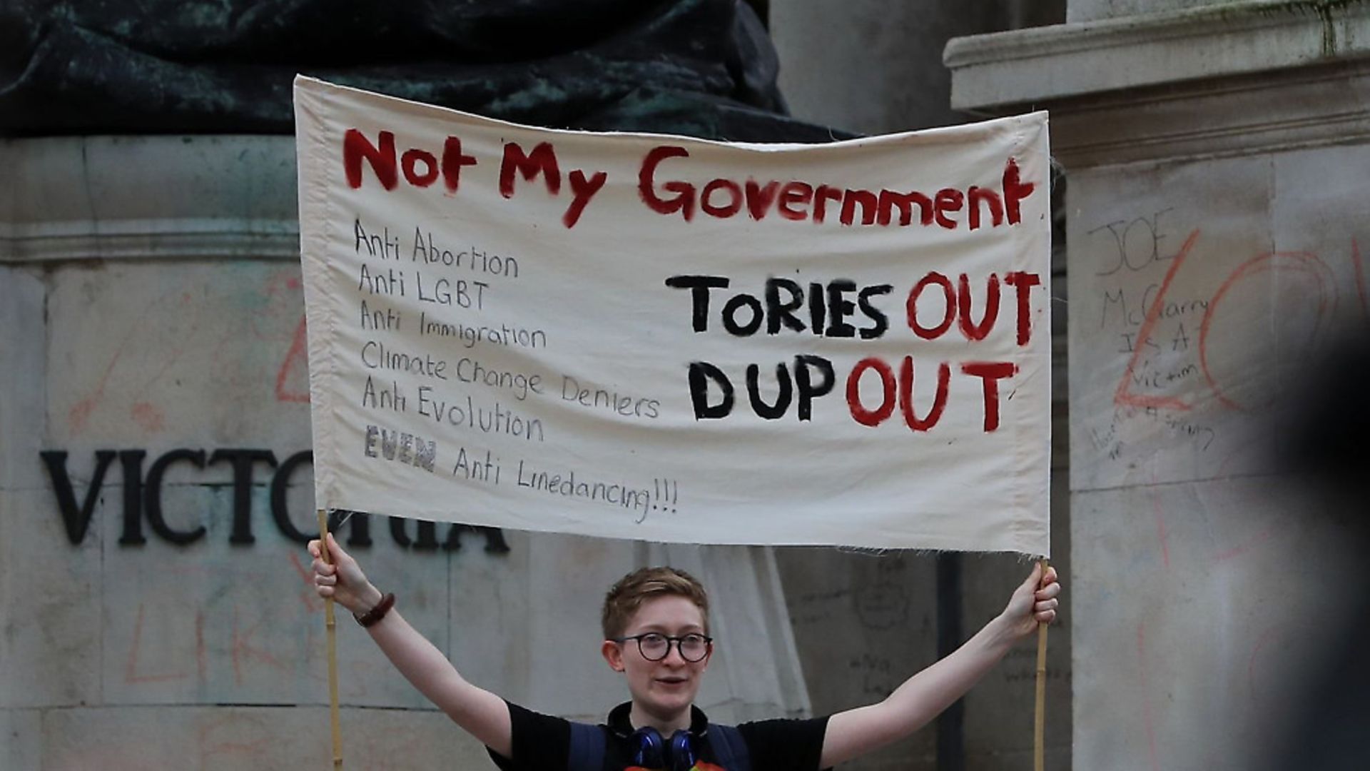 A protester holds up a sign at a demonstration in Liverpool - Credit: PA Wire/PA Images