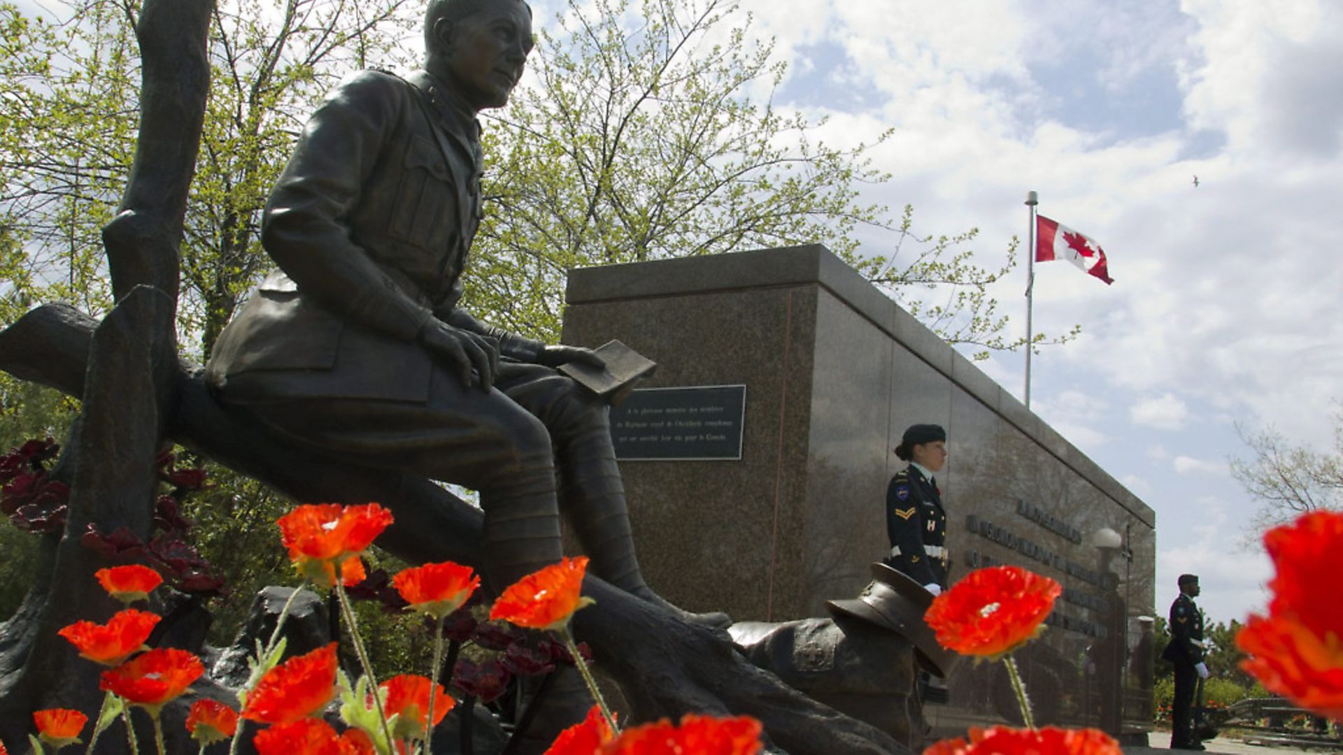 Poppies surround the newly unveiled statue of Lt.-Col. John McCrae to commemorate the Second Battle of Ypres - Credit: The Canadian Press/PA Images