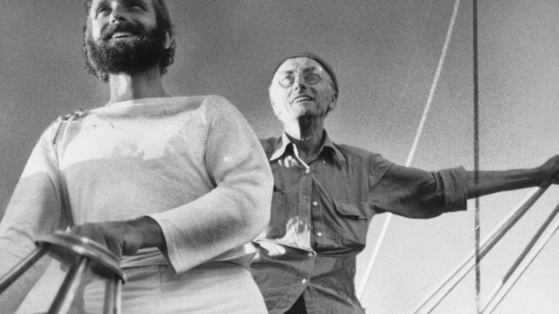 Jacques Cousteau, background, and his son, Phillipe, at the wheel of a ship. - Credit: Bettmann Archive