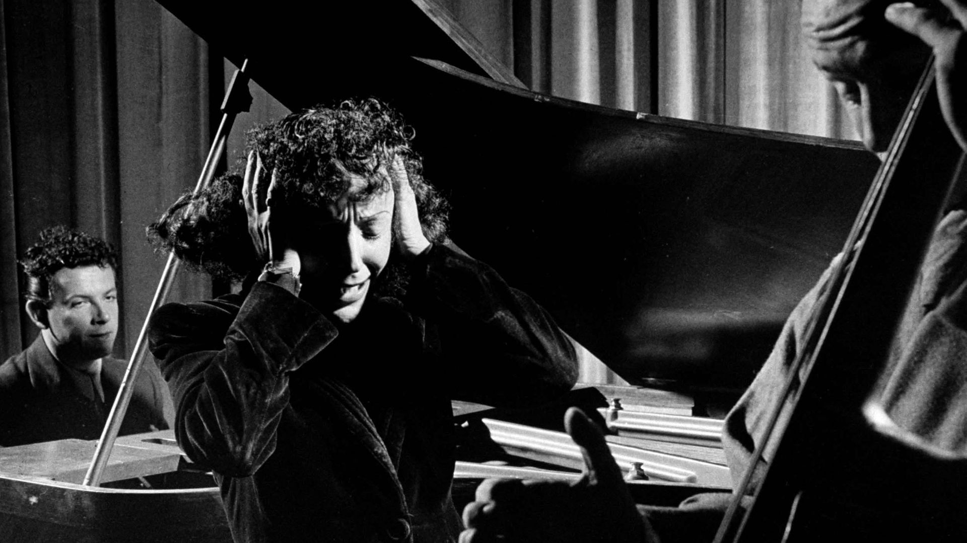 Edith Piaf holding her hands to her head while performing - Credit: The LIFE Picture Collection via