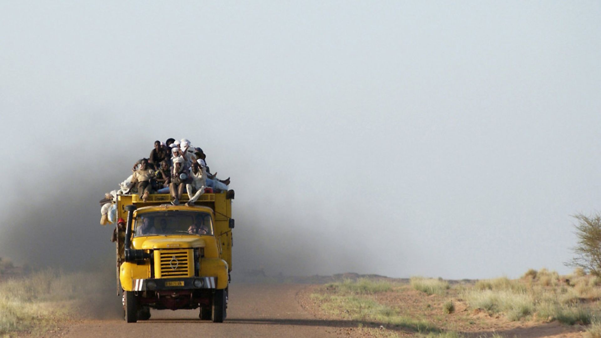 African migrants travel in the back of a truck across the Sahara Desert, near Agadez, Niger. Photo: Getty Images. - Credit: Getty Images