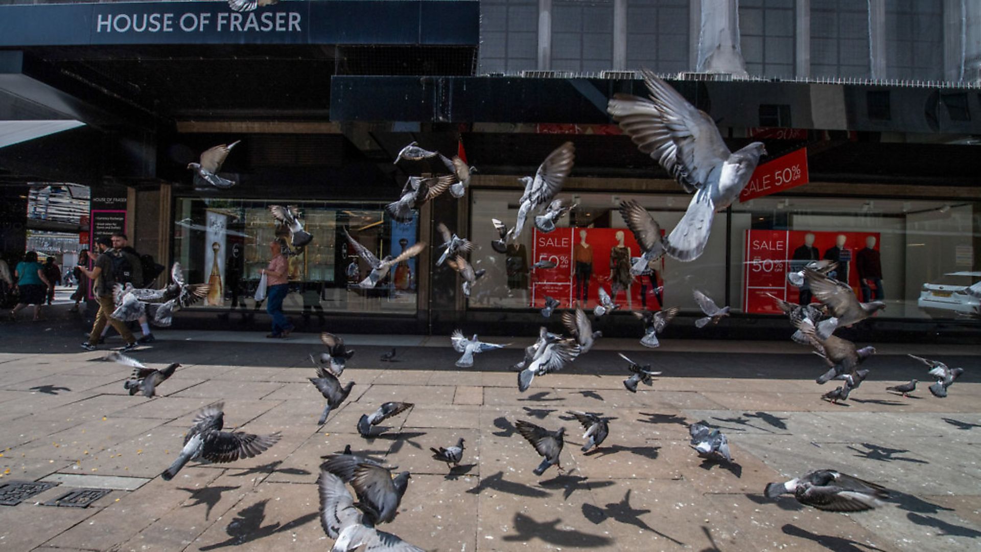 Pigeons fly in front of a House of Fraser store. Photographer: Chris J. Ratcliffe/Bloomberg via Getty Images - Credit: Bloomberg via Getty Images