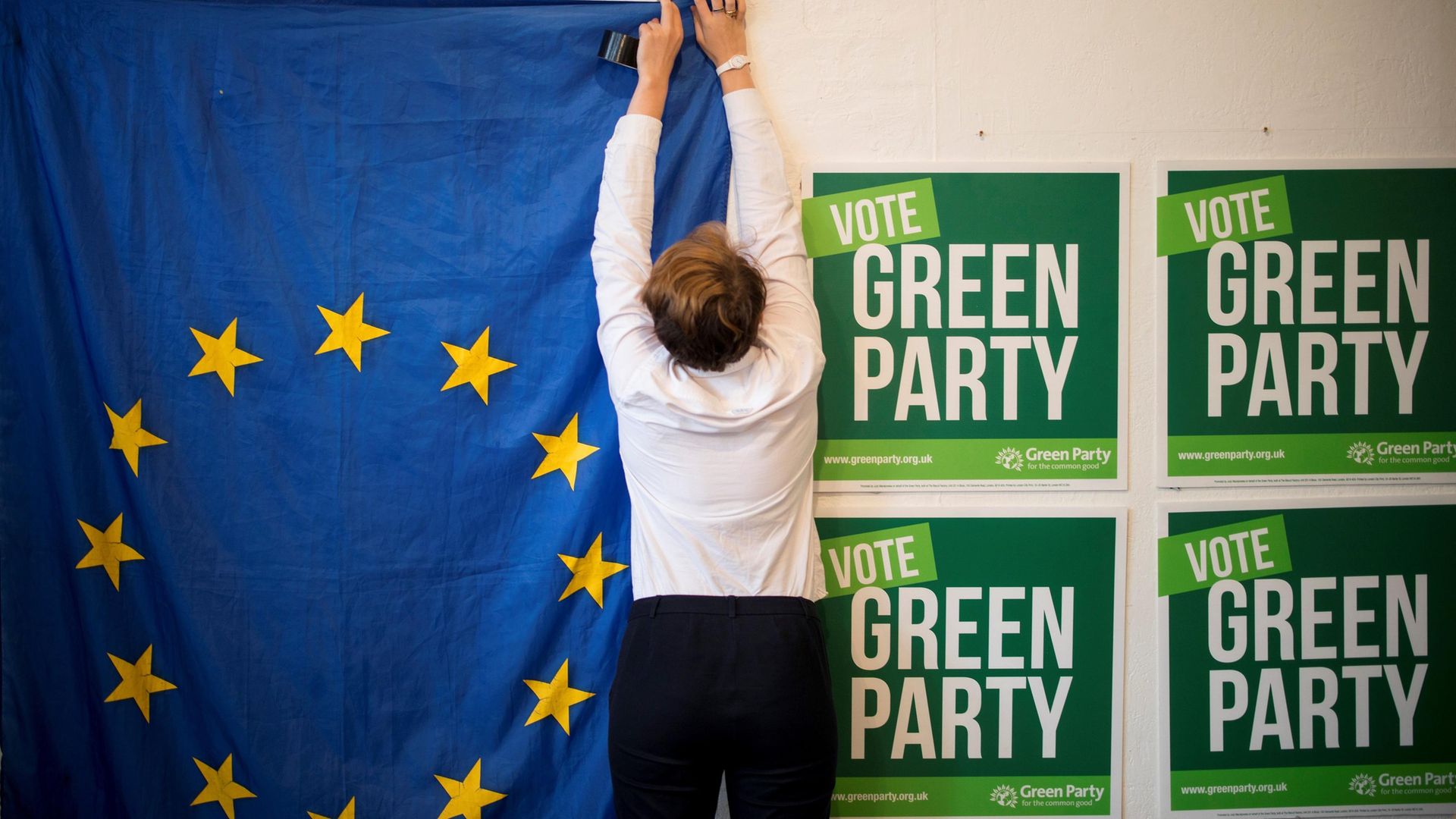 Volunteers hang a EU flag as they prepare the room for the launch of the Green Party's European election campaign in central London on May 8, 2019 - Credit: AFP via Getty Images