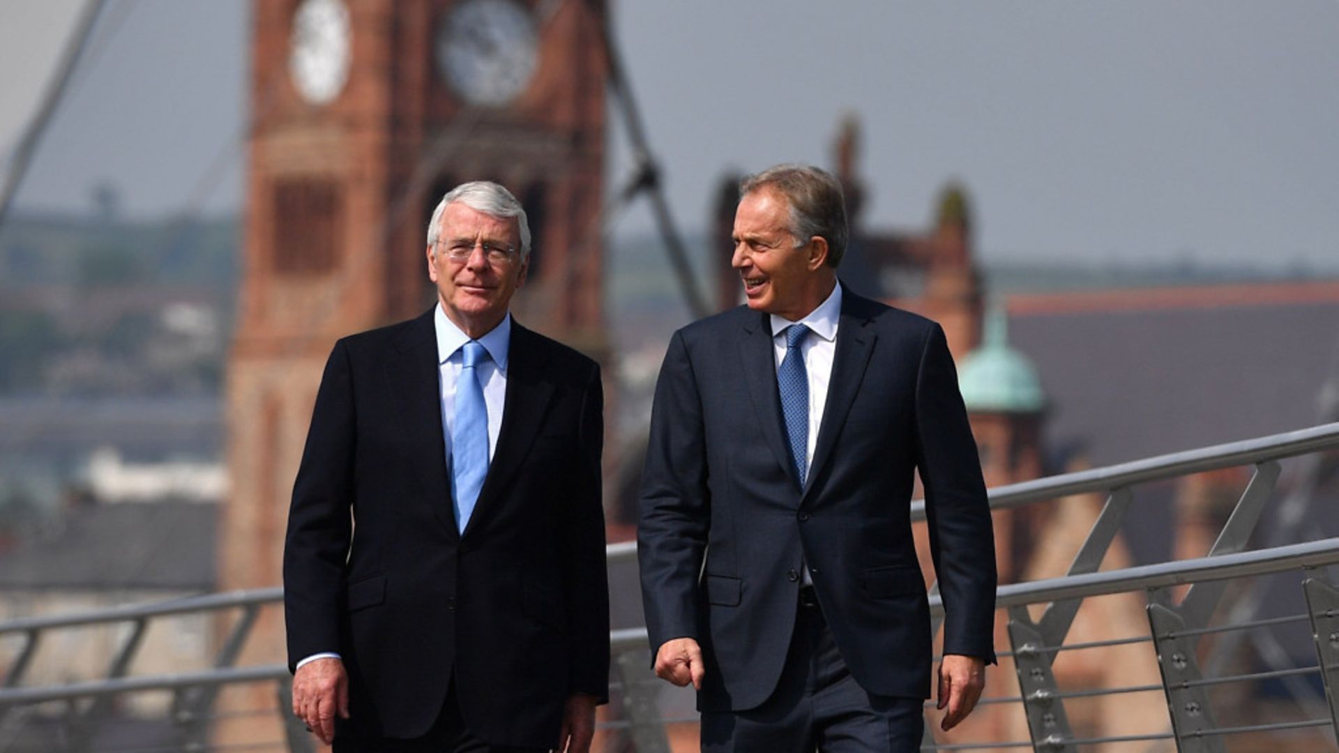Former prime ministers Sir John Major (left) and Tony Blair walk across the Peace Bridge in Londonderry - Credit: PA Archive/PA Images