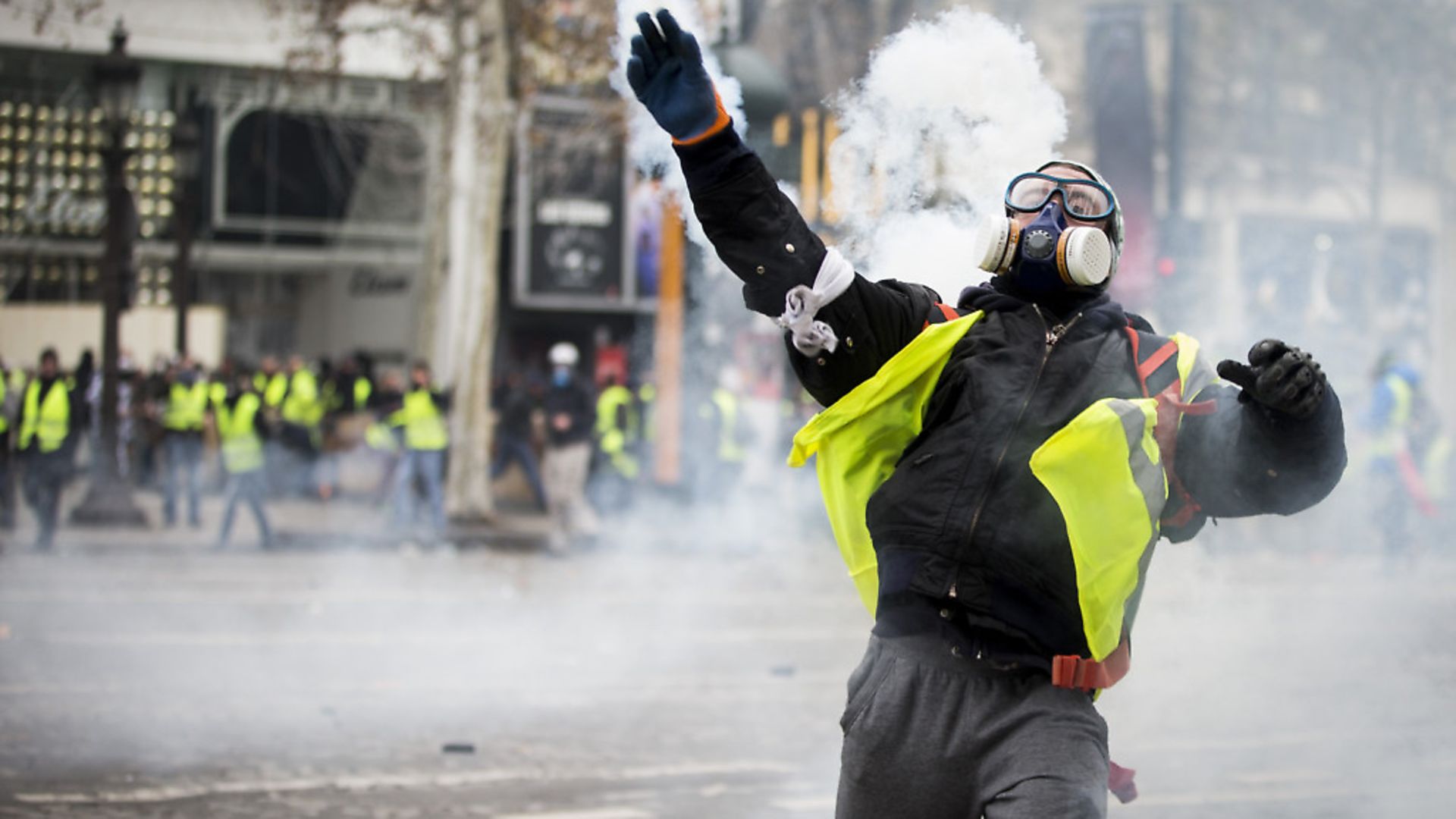 A yellow-vest protester throws back a teargas canister toward police officers near the Arc De Triomphe (question eight) (Photo by Sathiri Kelpa/SOPA Images/LightRocket via Getty Images) - Credit: LightRocket via Getty Images
