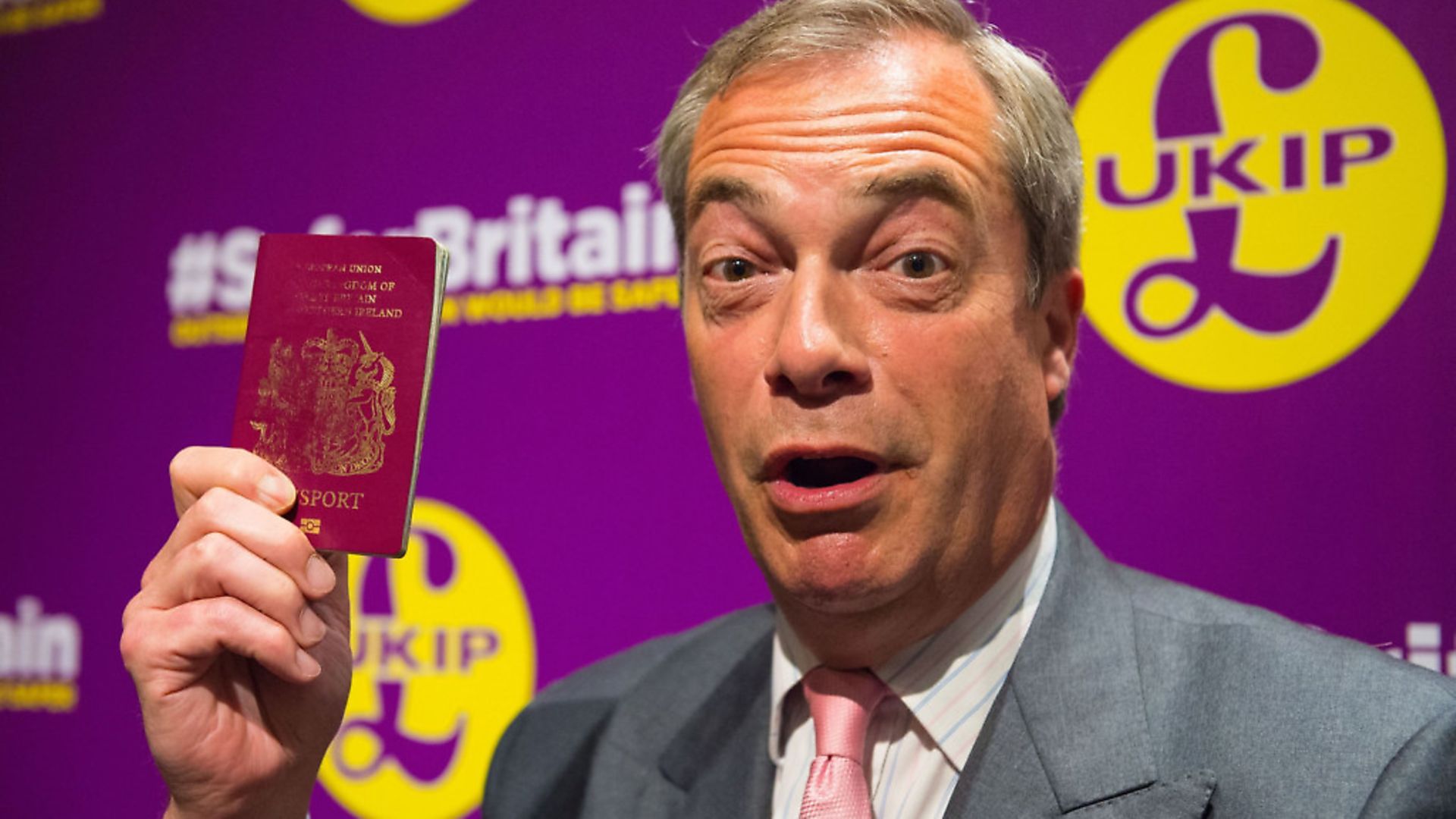 Nigel Farage holds up a burgundy passport. Photograph: Dominic Lipinski/PA. - Credit: PA Archive/PA Images