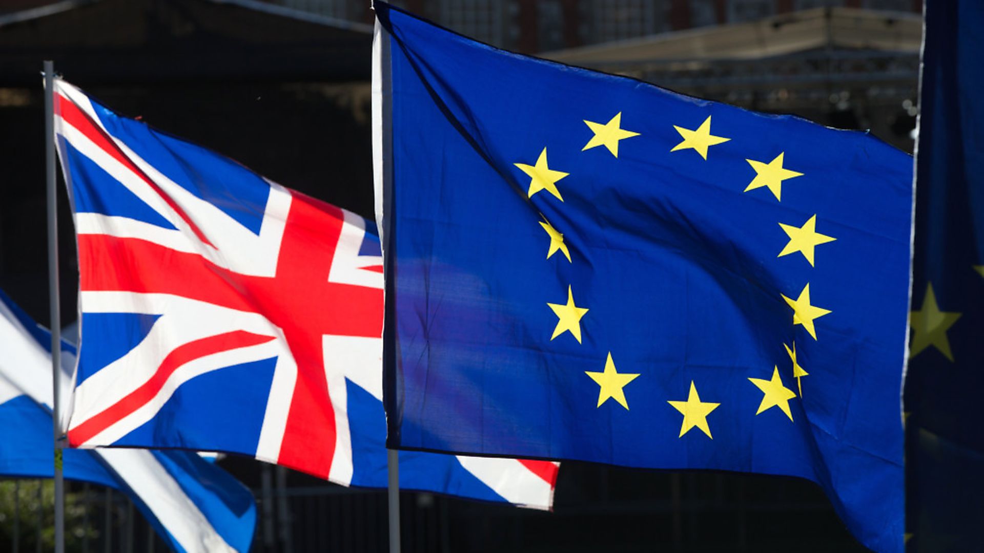 Anti-Brexit campaigners wave Union and European Union flags outside the Houses of Parliament. Photo: Jonathan Brady/PA