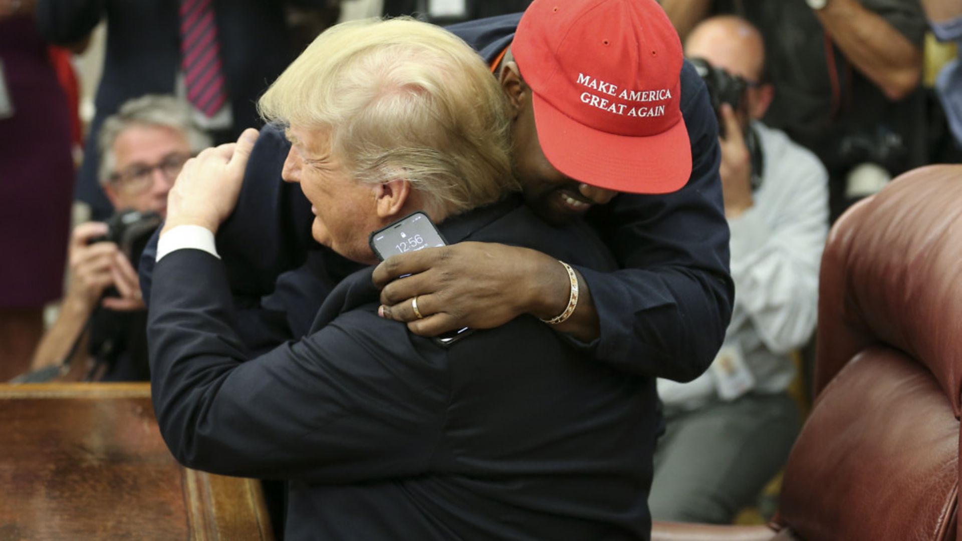 President Donald Trump hugs rapper Kanye West during a meeting in the Oval office - Credit: Getty Images