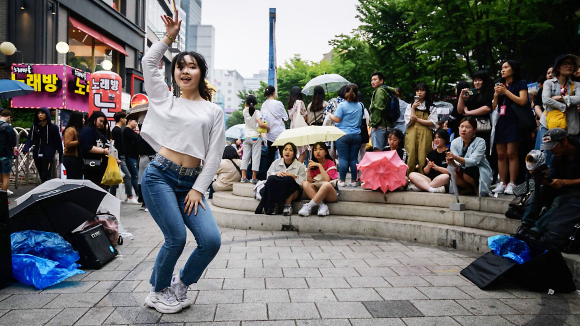 A dancer performs a k-pop routine for spectators on a street in the Hongdae district of Seoul. (Photo by Ed JONES / AFP) - Credit: AFP/Getty Images