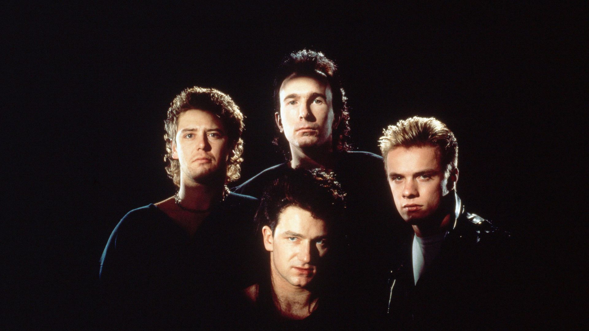 Adam Clayton (far left), The Edge (back), Bono (front) and Larry Mullen, Jr. (far right) form the rock band U2. - Credit: Corbis via Getty Images
