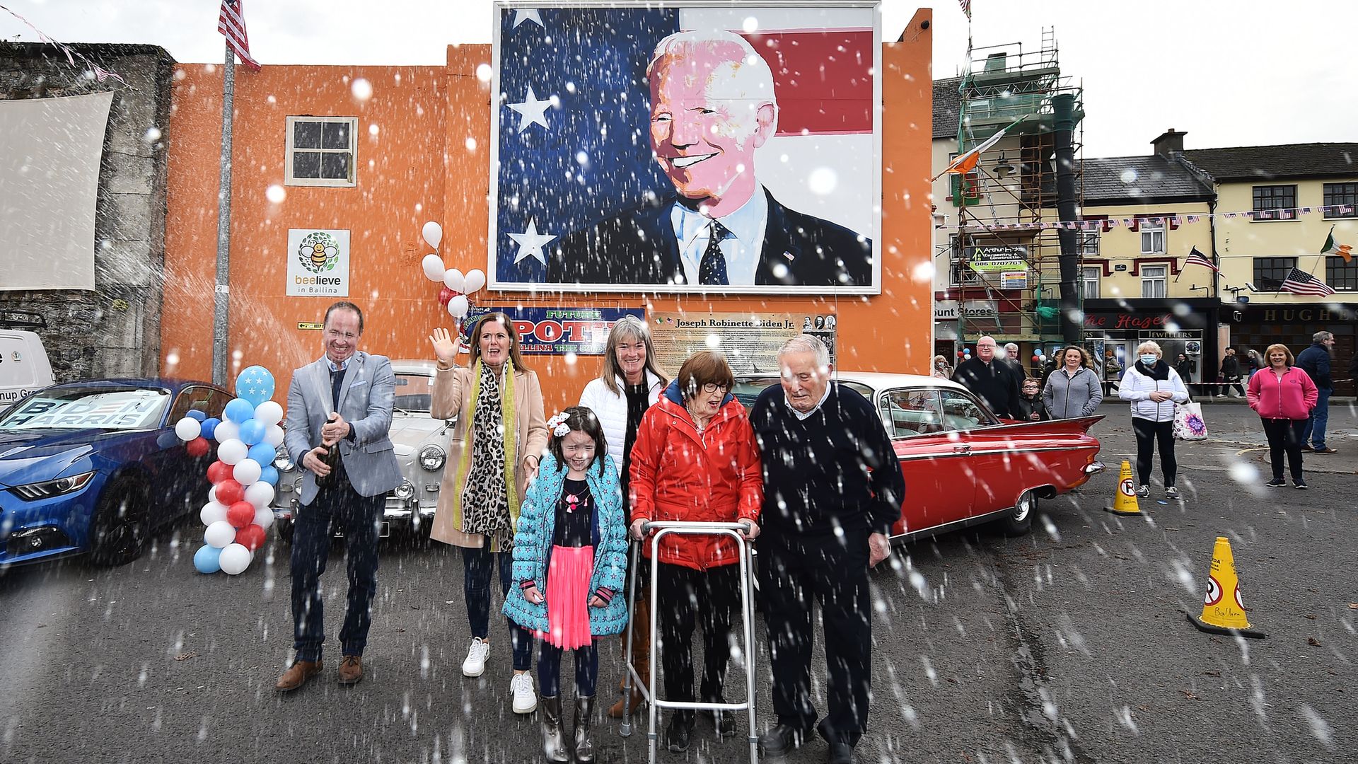 Joe Blewitt a cousin of Joe Biden sprays a bottle of champagne along with family members underneath a mural of the president-elect in Ballina, Ireland, where his relatives hail from - Credit: Getty Images