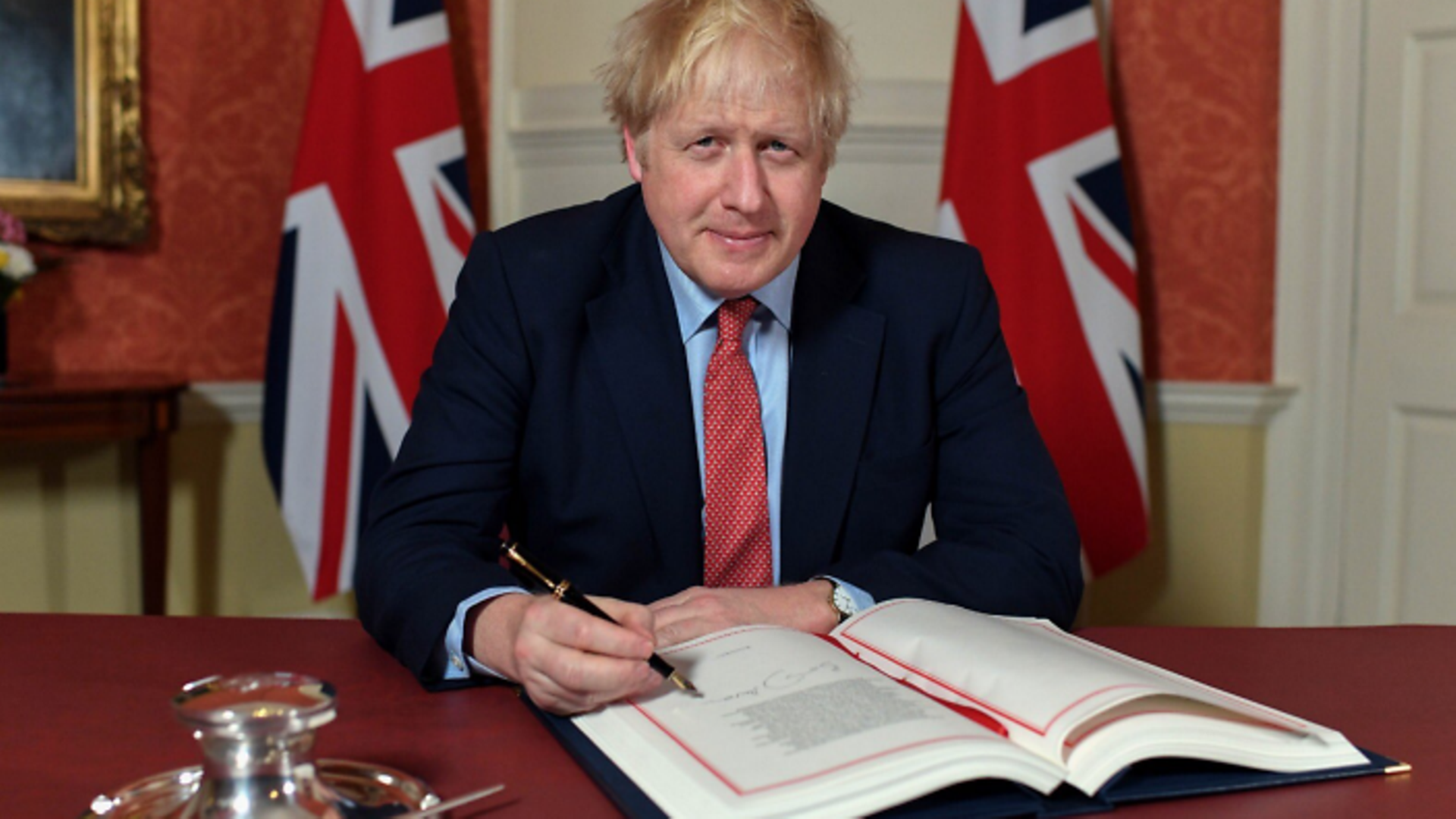 Boris Johnson signs the Withdrawal Agreement in January - Credit: Twitter