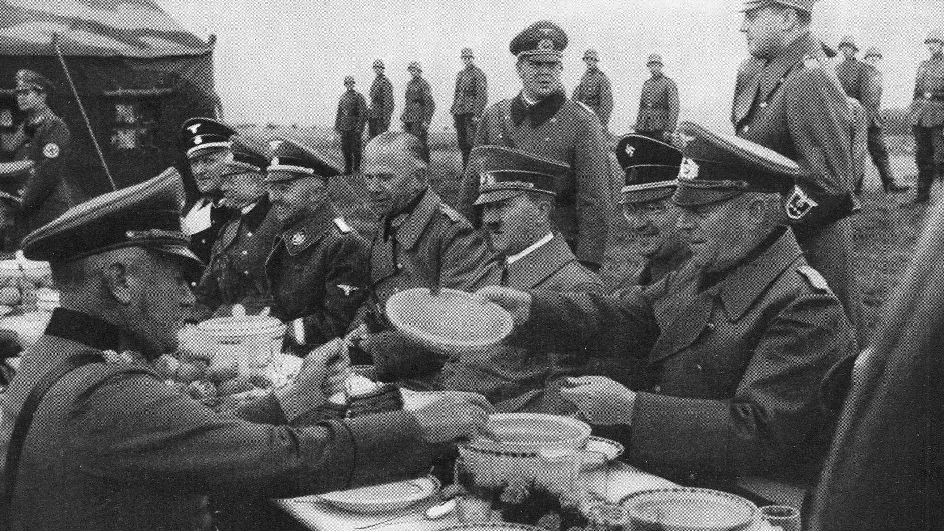 Nazi leader Adolf Hitler dines alfresco with a group of generals, circa 1940 (question one) - Credit: Henry Guttmann/Hulton Archive/Getty Images