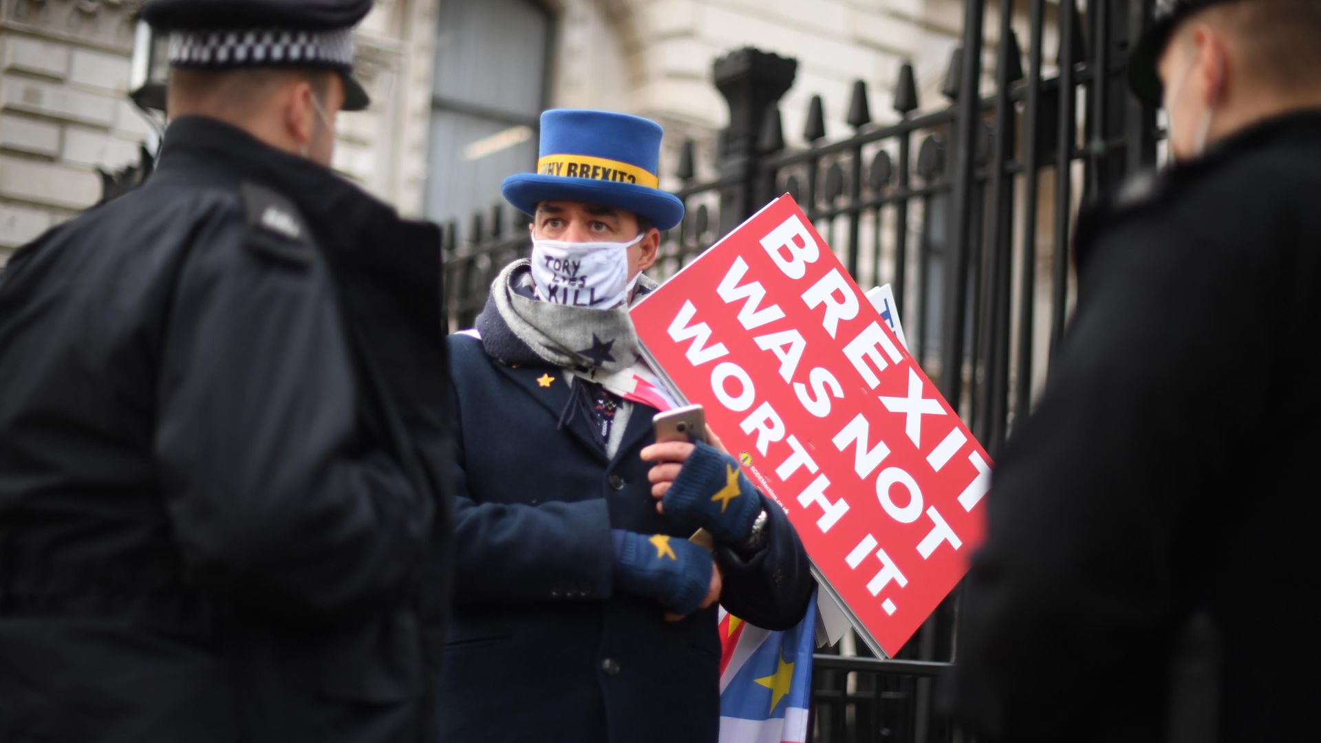 Police officers speak to an anti-Brexit protester at the gates of Downing Street, London - Credit: PA