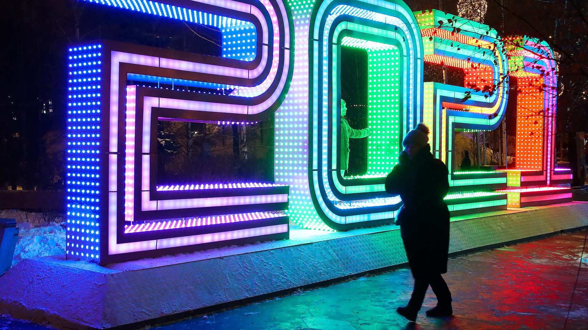 A woman stands next to a light installation set up to spell 2021 at Zaryadye Park, Moscow, ahead of New Year celebrations - Credit: Valery Sharifulin/TASS