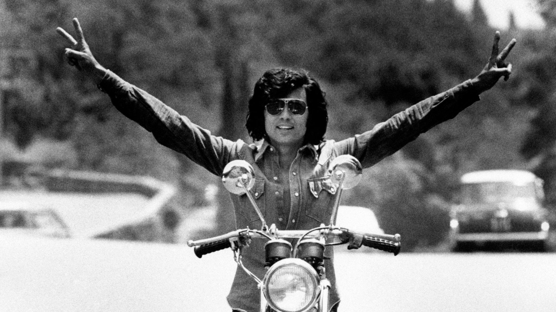 The Sammarinese singer Little Tony, born Antonio Ciacci, poses on a motorbike with open arms. - Credit: Mondadori via Getty Images