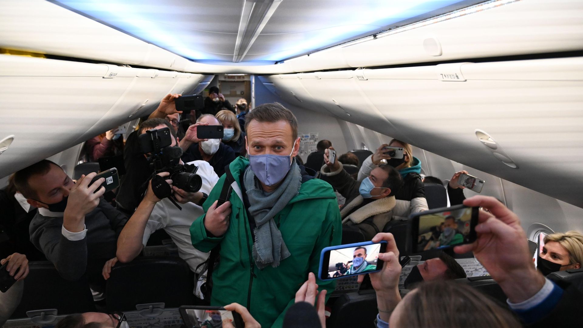 Russian opposition leader Alexei Navalny walks to take his seat on the aircraft taking him from Berlin to Moscow - Credit: AFP via Getty Images