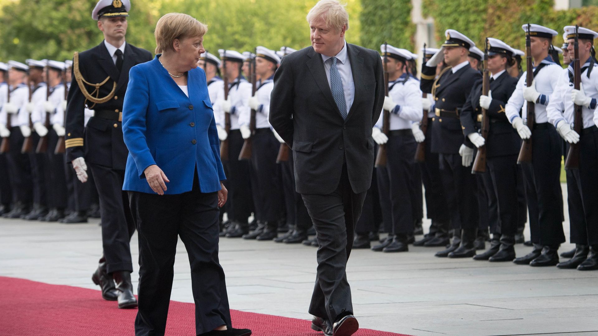 Prime Minister Boris Johnson walks with German Chancellor Angela Merkel in Berlin - Credit: PA