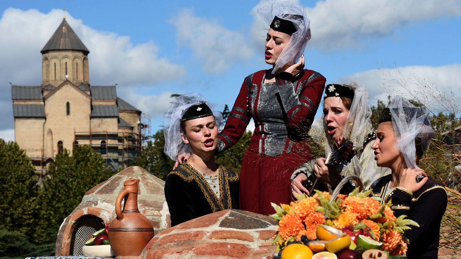 Georgian musicians wearing national dresses sing during the 'Tbilisoba' annual arts festival in Tbilisi  in 2016 - Credit: AFP via Getty Images