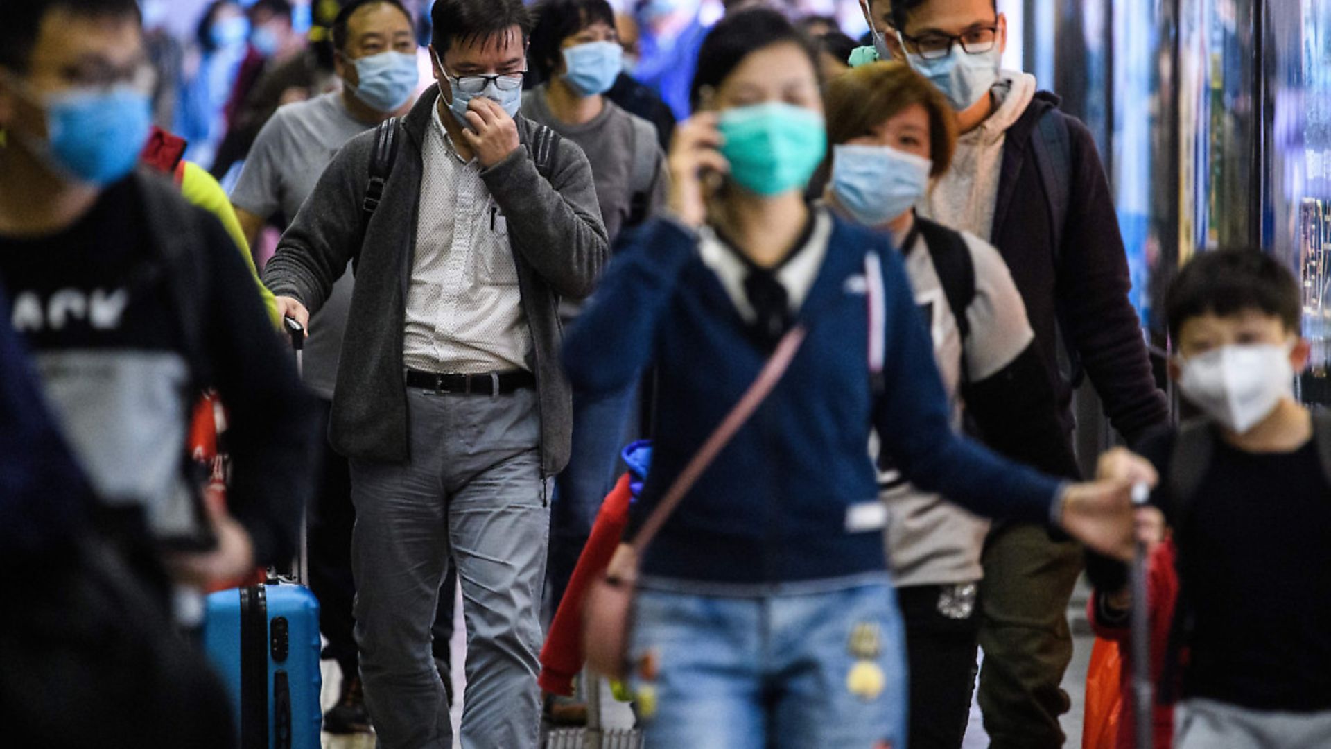 Passengers wear protective face masks as they arrive from Shenzhen to Hong Kong. Picture: ANTHONY WALLACE/AFP via Getty Images - Credit: AFP via Getty Images