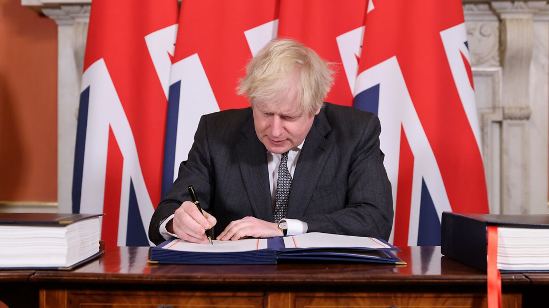 Boris Johnson signs the Brexit agreement - Credit: Andrew Parsons / No10 Downing St