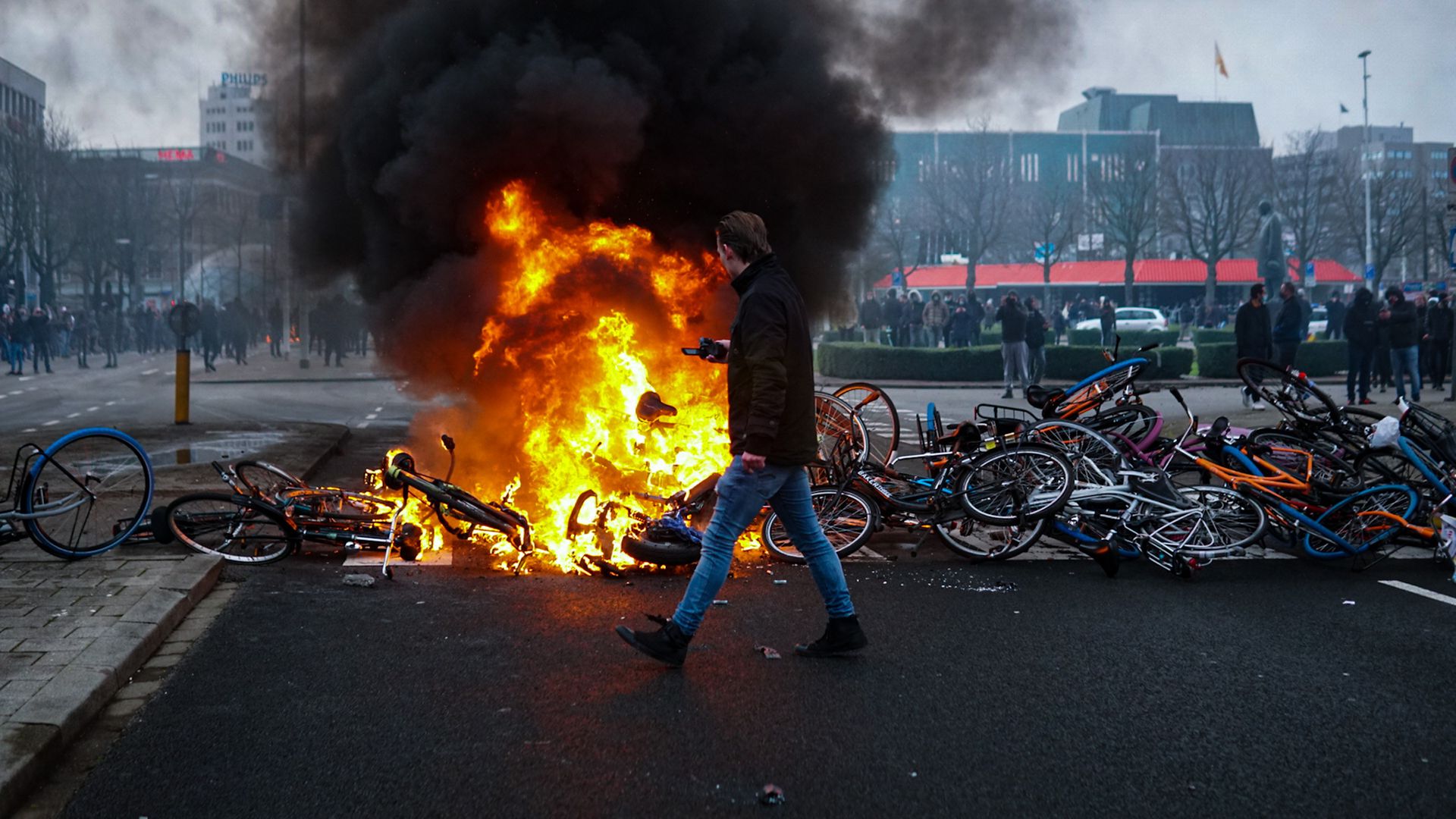 Rising anger: Protesters lay bikes down to block a street and set a fire during a protest against the coronavirus measures in Eindhoven in January - Credit: Anadolu Agency via Getty Images