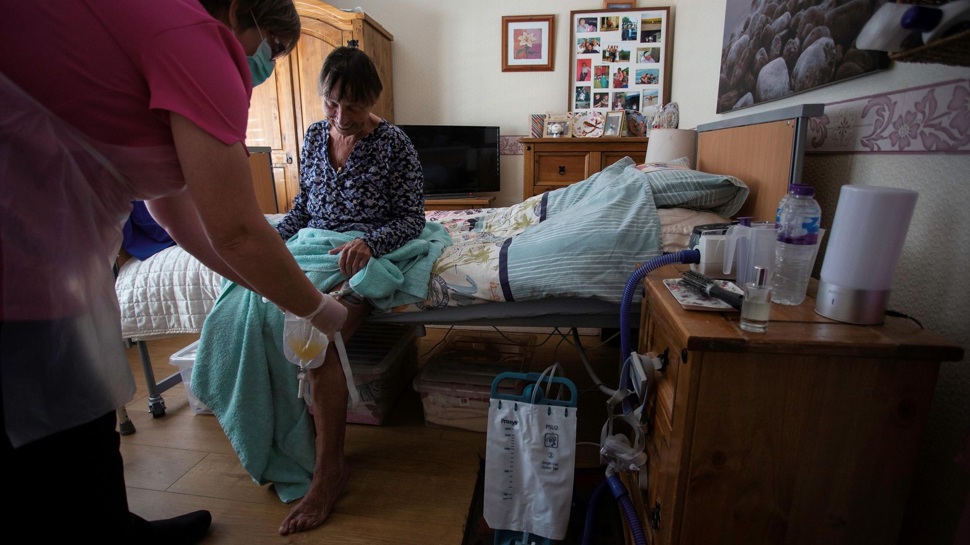 Dawn, a carer, tends to her client Tina during a home visit in Scunthorpe - Credit: AFP via Getty Images