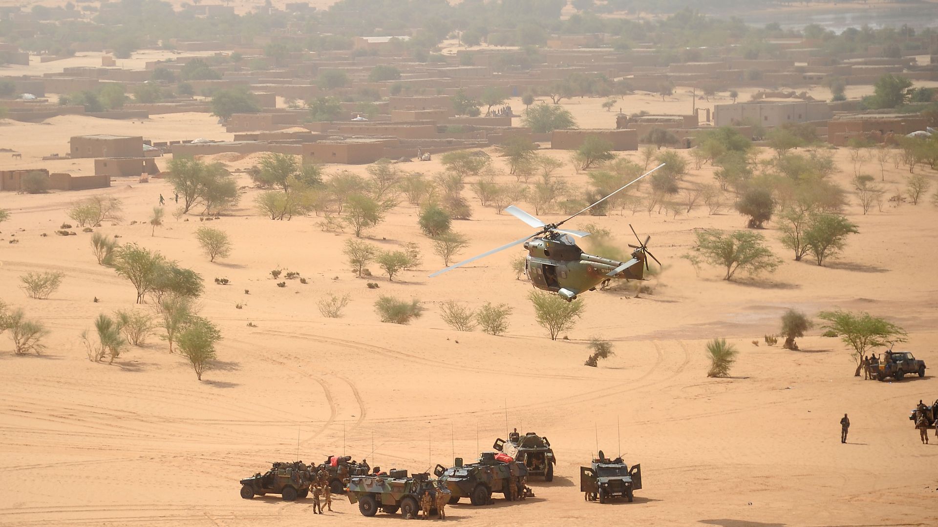 A Puma helicopter flies above French military vehicles near Bourem, northern Mali - Credit: AFP via Getty Images