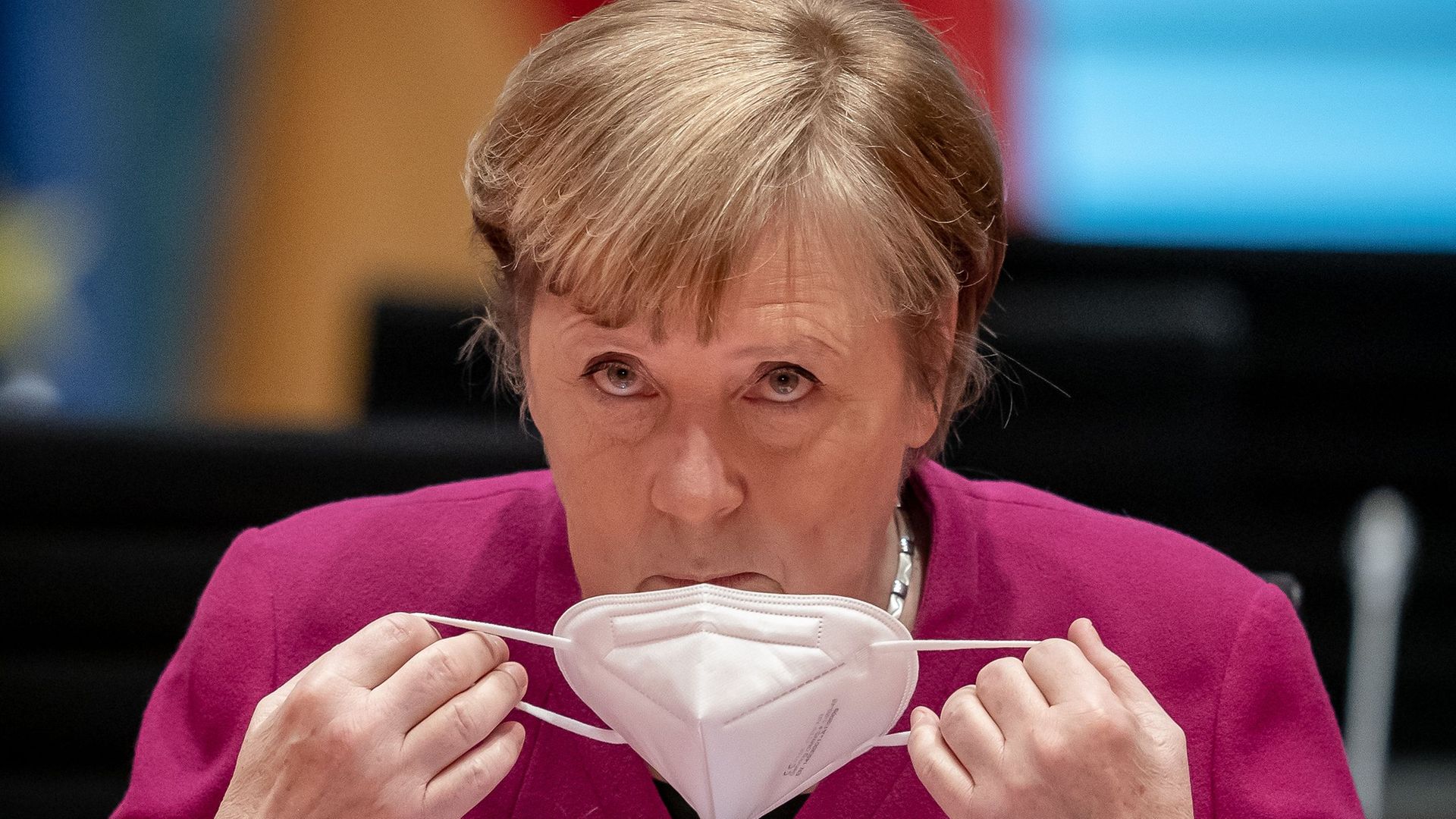 Angela Merkel removes her face mask at the start of a cabinet meeting at the Chancellery in Berlin - Credit: POOL/AFP via Getty Images