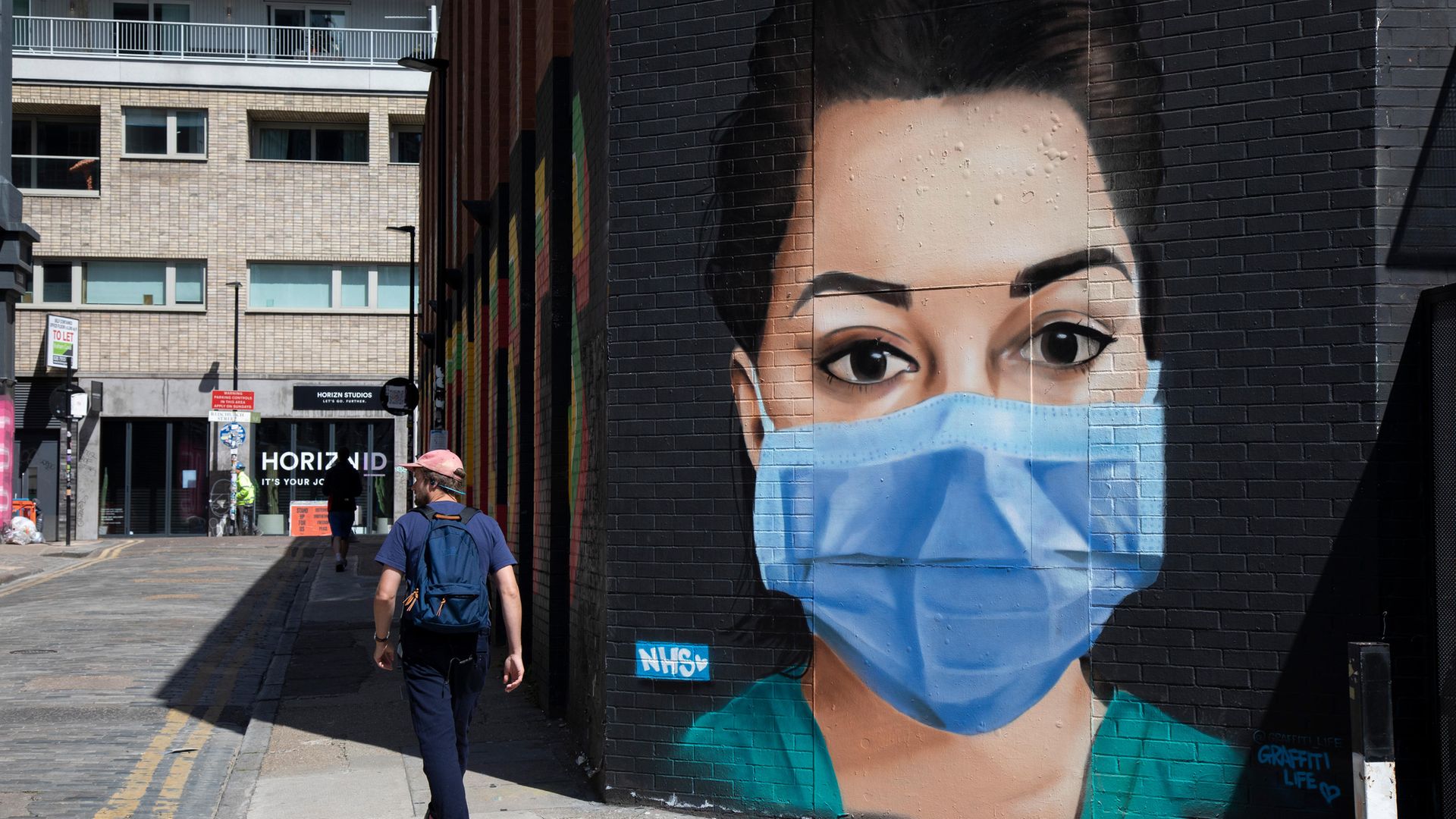 A mural of an NHS nurse wearing a face mask in east London - Credit: In Pictures via Getty Images