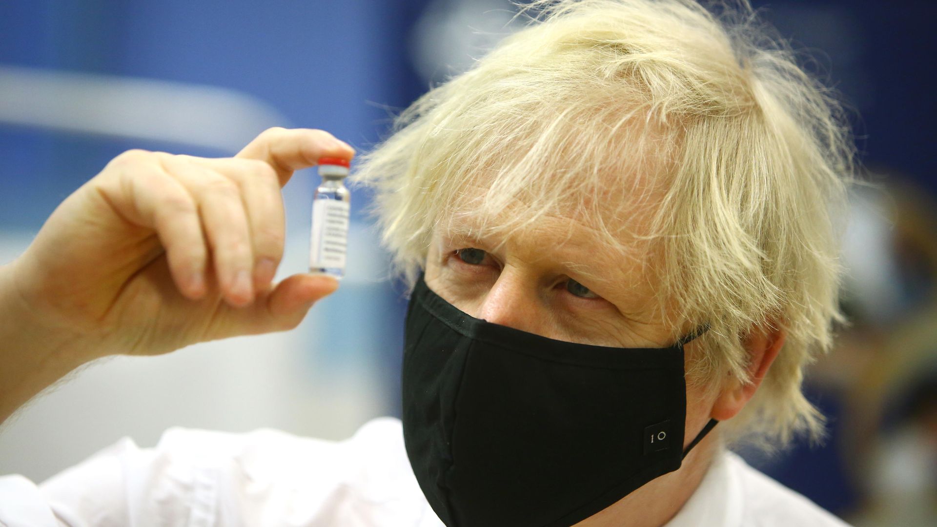 Prime minister Boris Johnson holding a vial of the Oxford/Astra Zeneca Covid-19 vaccine as he visits a vaccination centre at Cwmbran Stadium in Cwmbran, south Wales. Picture date: Wednesday February 17, 2021. - Credit: PA