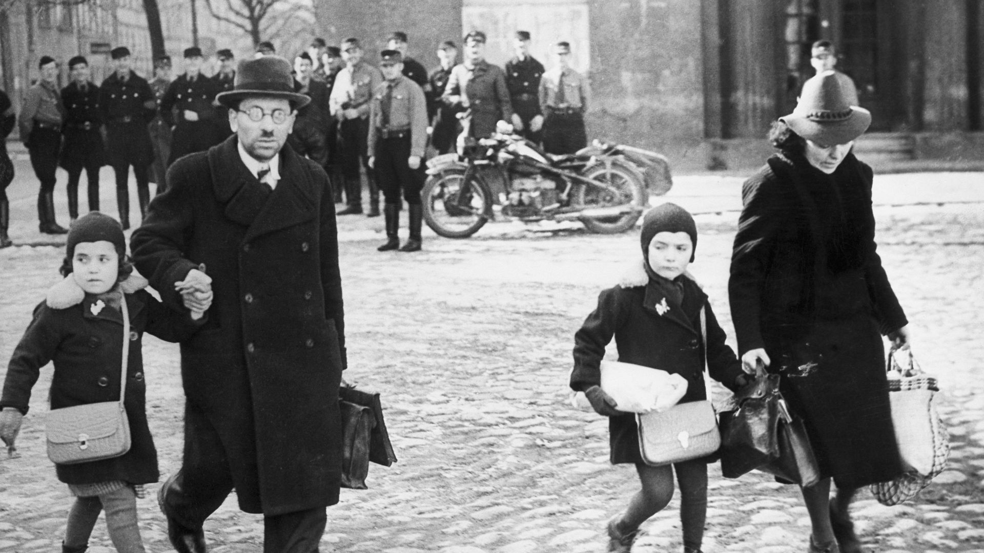 Uniformed Nazis watch a family of refugee Jews fleeing from Memel – now Klaipėda – after it was occupied by Germany in 1939, Adolf Hitler's last territorial acquisition before the war - Credit: Bettmann Archive