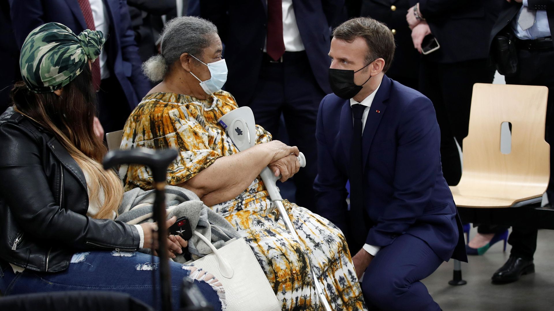 French President Emmanuel Macron, wearing a protective face mask, talks to a patient as he visits a coronavirus vaccination centre - Credit: POOL/AFP via Getty Images