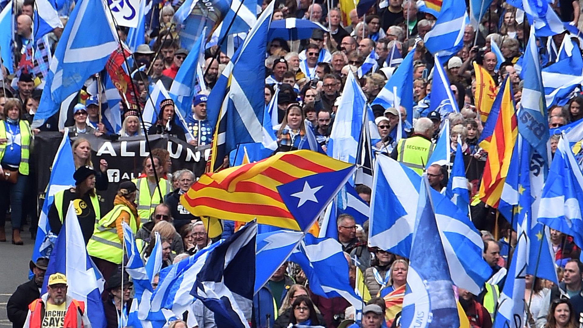 Catalan Estelada flags fly alongside Saltires at a pro-Scottish independence march in Glasgow in May, 2019 - Credit: AFP via Getty Images