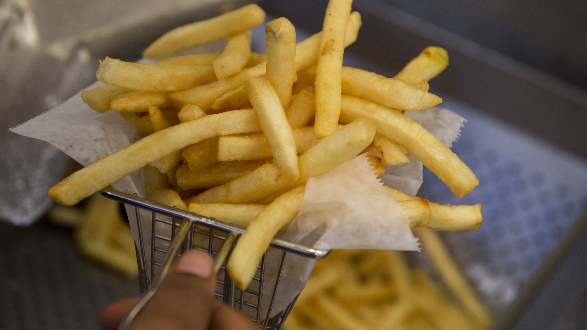 A chips cook prepares french fries from a fryer in the kitchen at Bolt Burgers in Washington, DC, February 25, 2014 - Credit: Photo by SAUL LOEB/AFP via Getty Images