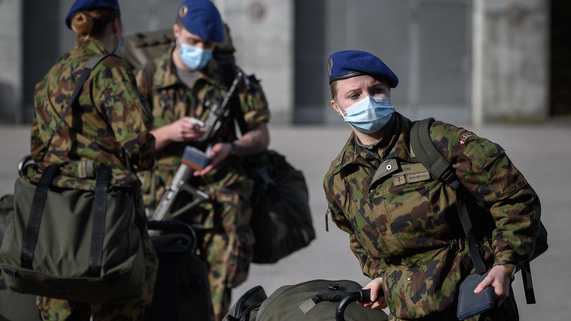 Swiss army reservists wearing protective face masks arrive at Moudon military base on November 8, 2020 - Credit: Photo by Fabrice Coffrini/AFP via Getty Images