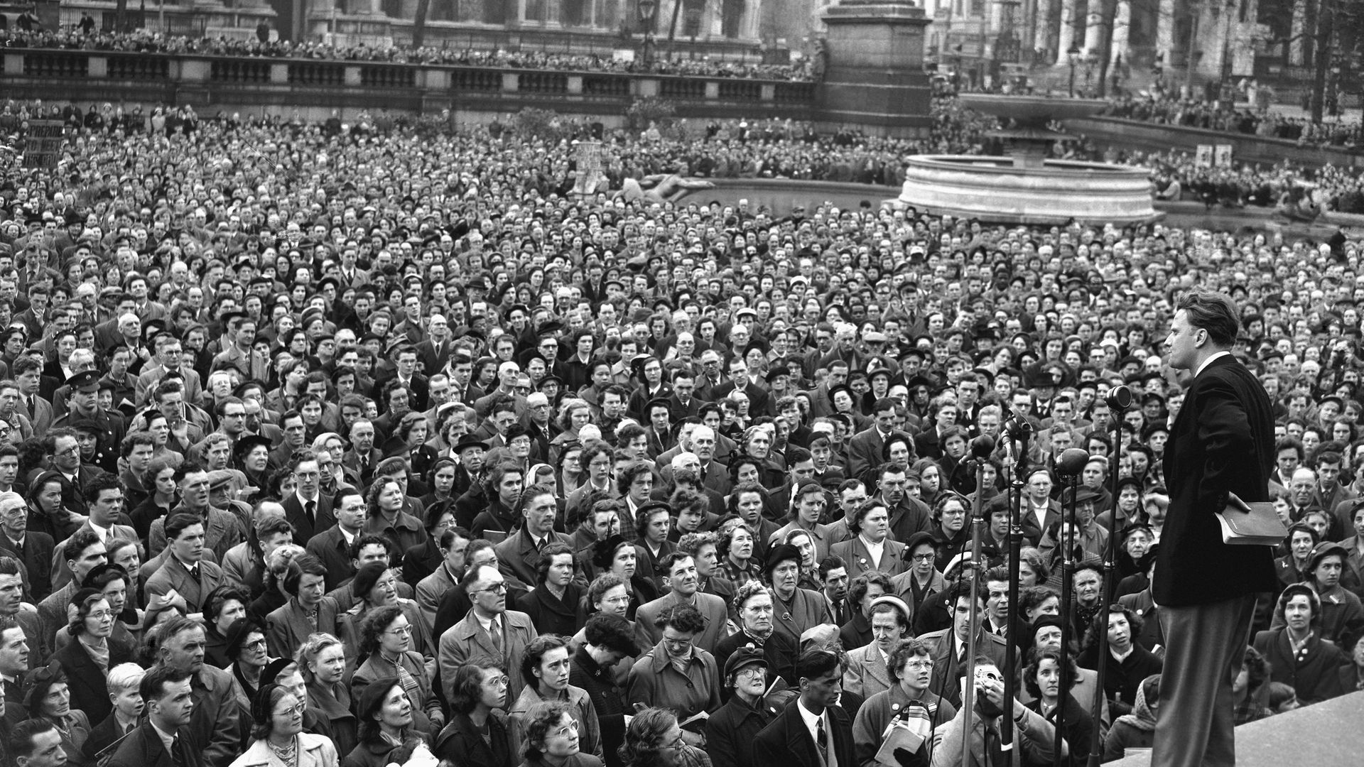 Bible in hand, American evangelist Billy Graham speaks to a crowd in Trafalgar Square in 1954 - Credit: Bettmann Archive