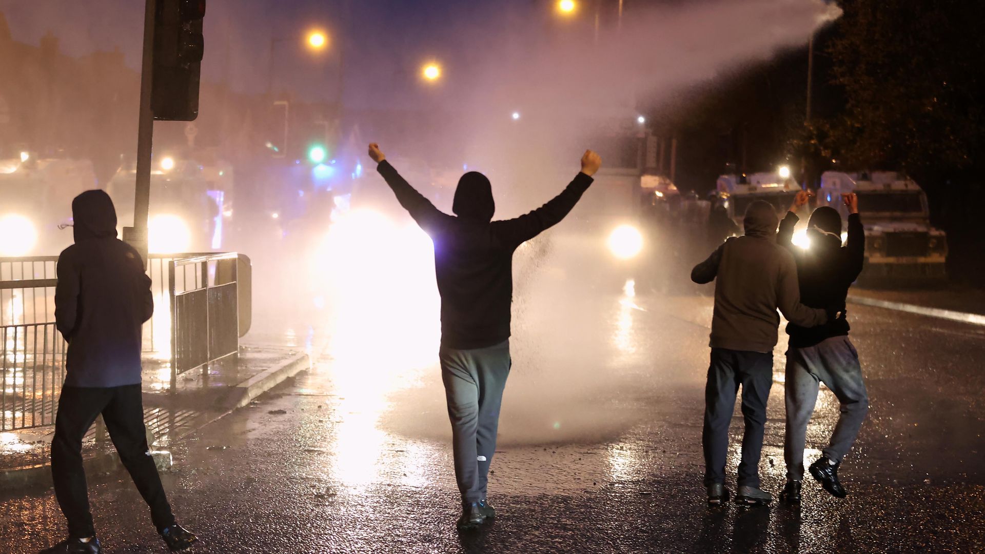 The PSNI use a water cannon on youths on the Springfield road, during further unrest in Belfast - Credit: PA