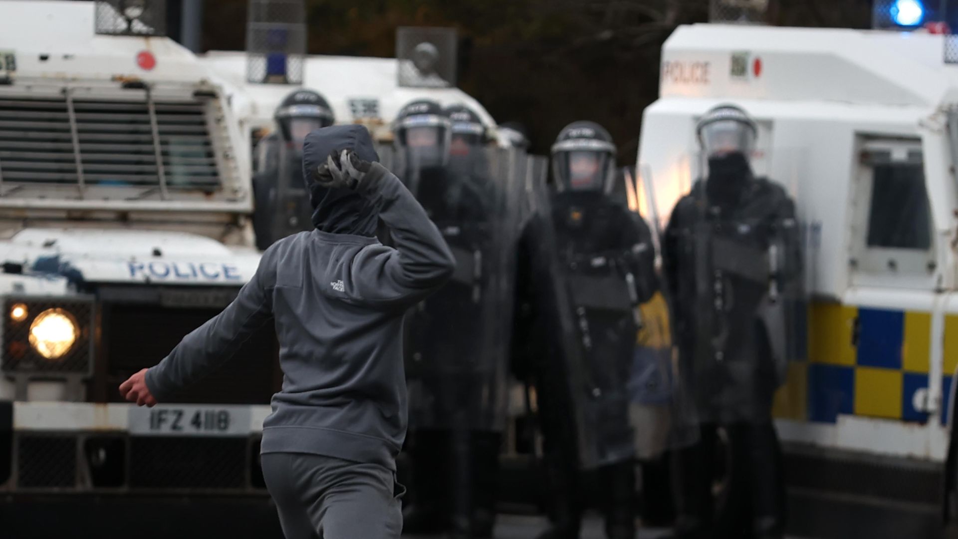 Youths throw stones towards PSNI officers on the Springfield road, during further unrest in Belfast - Credit: PA