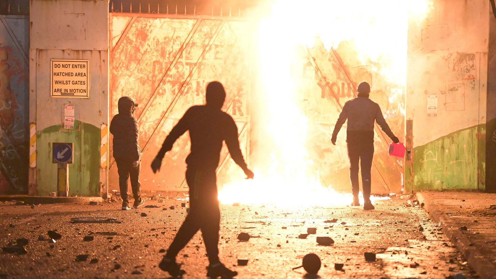 VIOLENCE AT THE PEACE GATE: Fire fed by petrol burns as youths clash with police at Belfast's Springfield road/Lanark Way interface in early April - Credit: Charles McQuillan/Getty Images