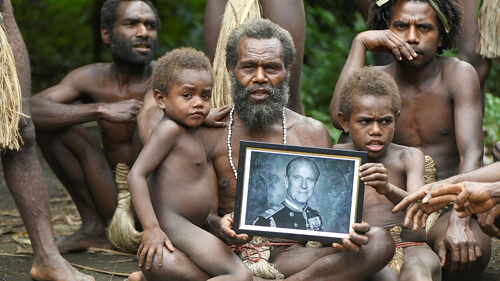 Yakel village chief Albi, and members of his family in the remote Pacific village of Vanuatu hold a portrait of Prince Philip, who they worshipped as a living god - Credit: Photo by Dan McGarry / AFP via Getty Images