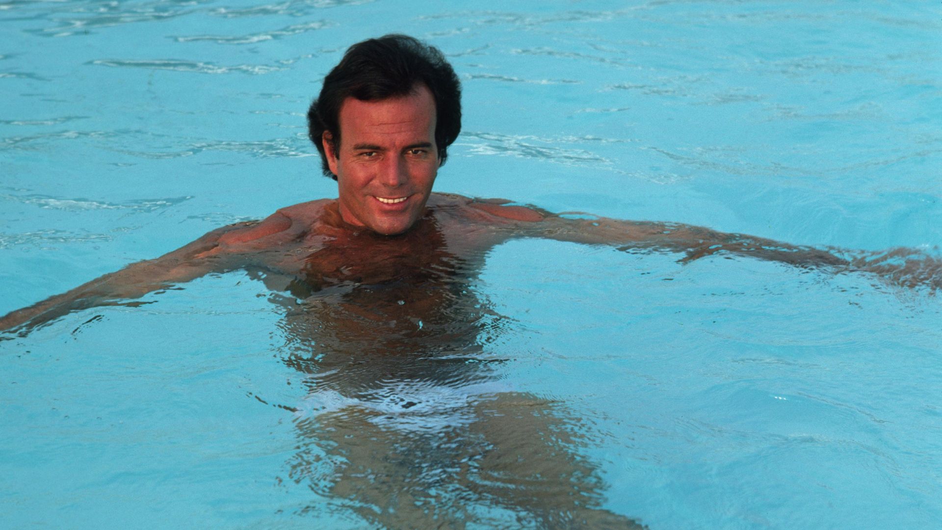 Julio Iglesias in the pool, in Miami, 1980 - Credit: Getty Images
