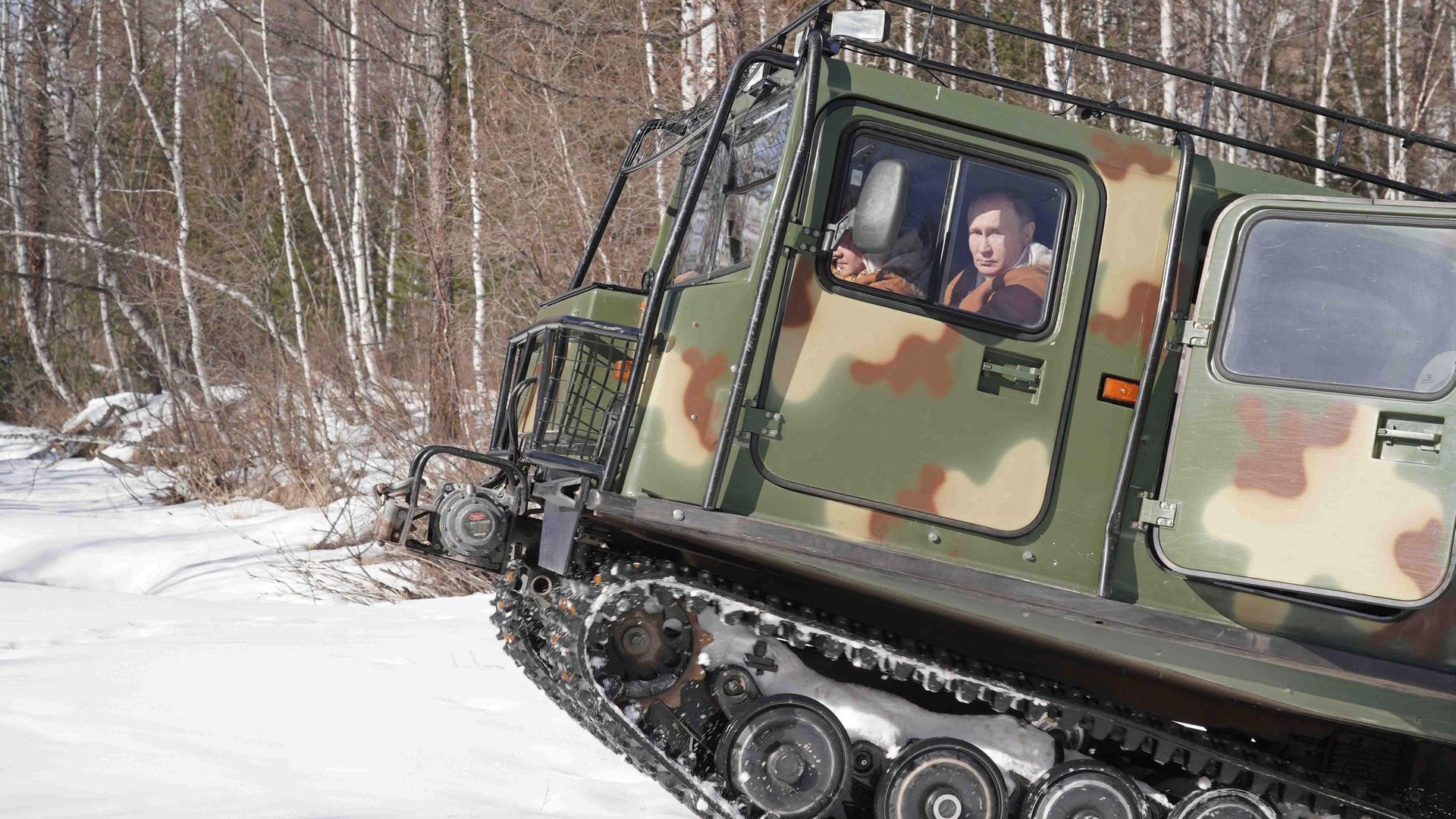 Vladimir Putin behind the wheel of an all-terrain vehicle while driving through a taiga forest in Siberia, in March 2021 - Credit: Alexei Druzhinin/TASS