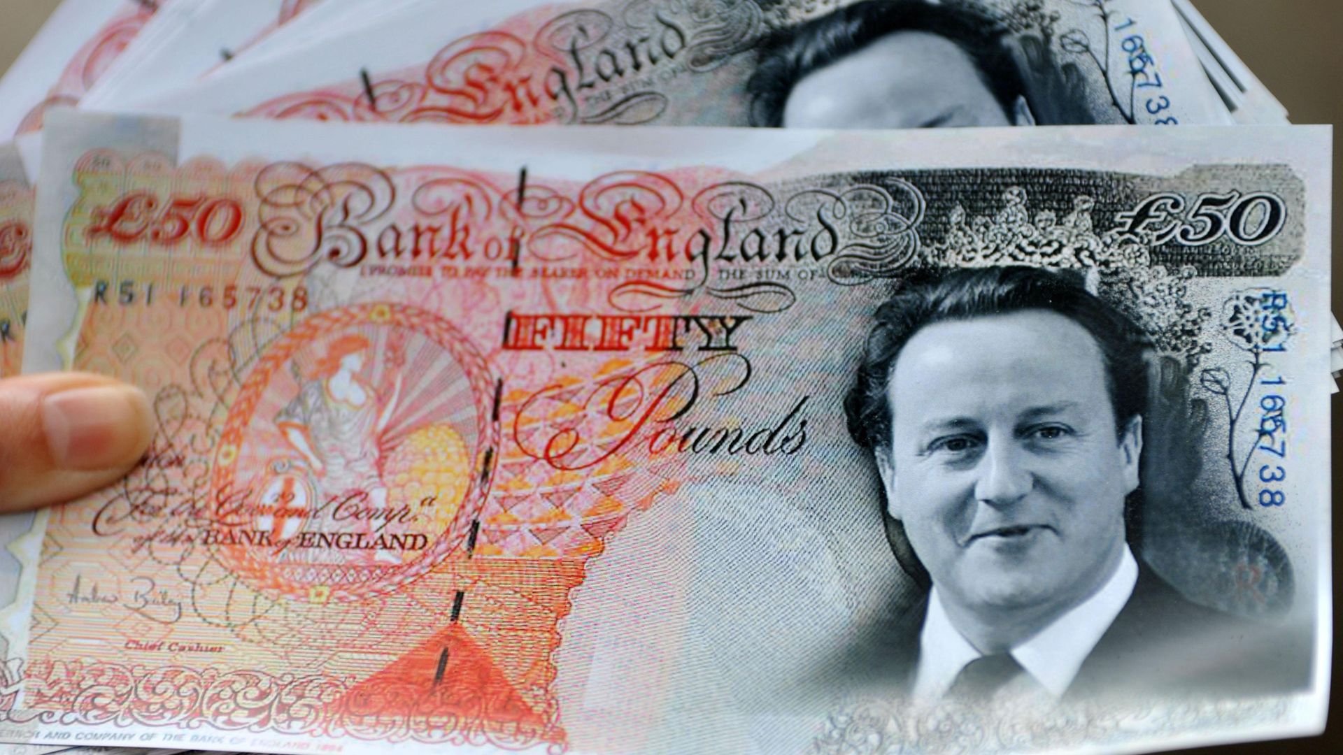 Mock £50 notes featuring the head of David Cameron, held by members of the union UNISON demonstrating his proposals for the NHS in 2011 - Credit: PA