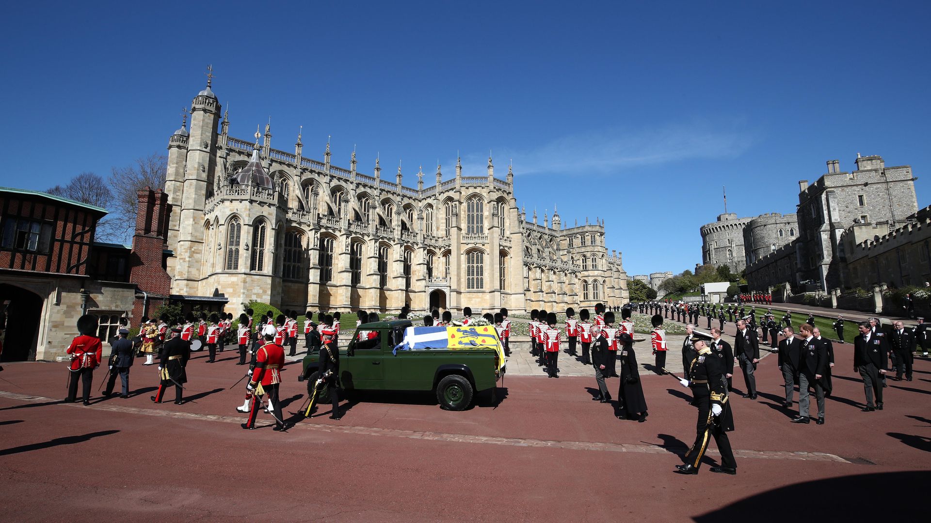 POMP: The Duke of Edinburgh's coffin, covered with his personal standard and carried by a Land Rover Defender hearse, passes through the Parade Ground followed by member of the Royal family during a procession for his funeral at Windsor Castle - Credit: Getty Images