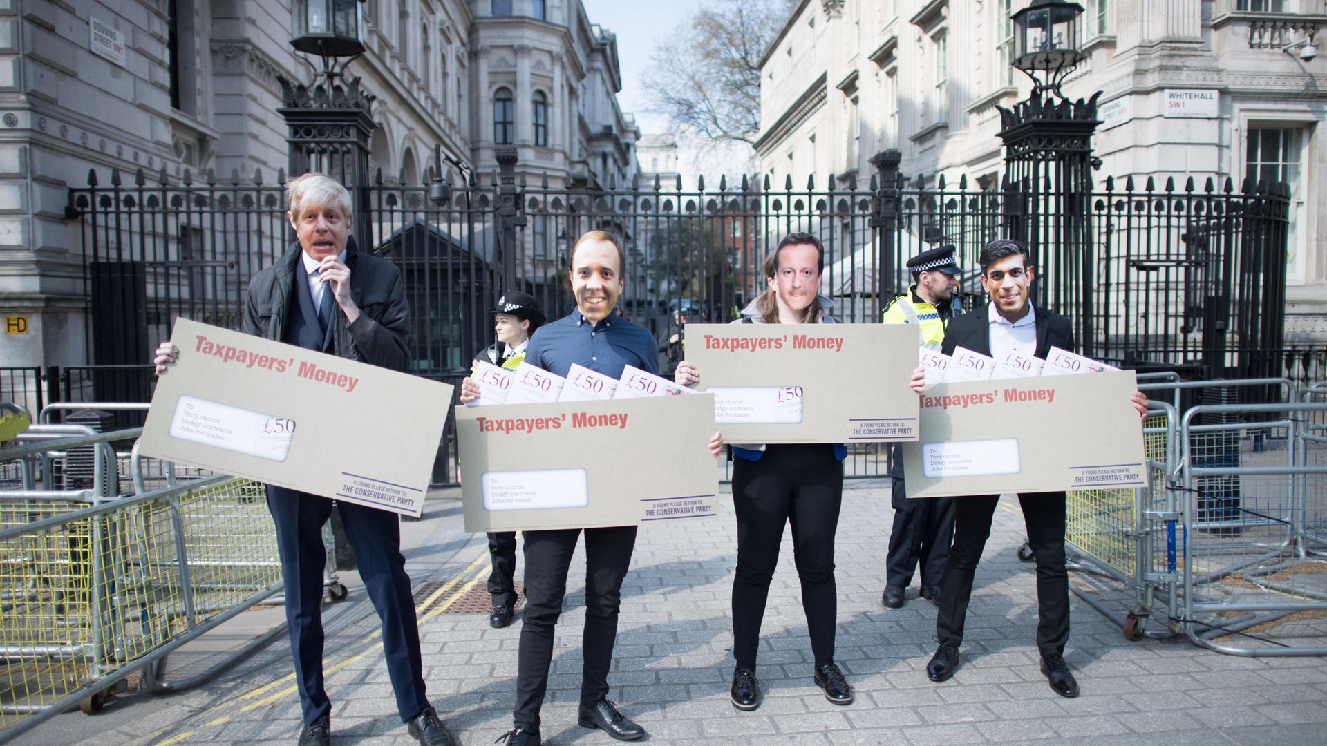 Labour activists wearing face masks, depicting prime minister Boris Johnson, chancellor Rishi Sunak, health secretary Matt Hancock and former PM David Cameron - Credit: PA