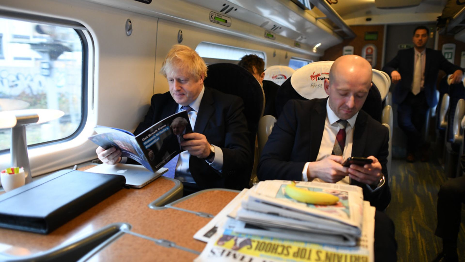 Boris Johnson, sitting with his former Director of Communications, Lee Cain (right), with a stack of newspapers on the train. - Credit: PA Wire/PA Images