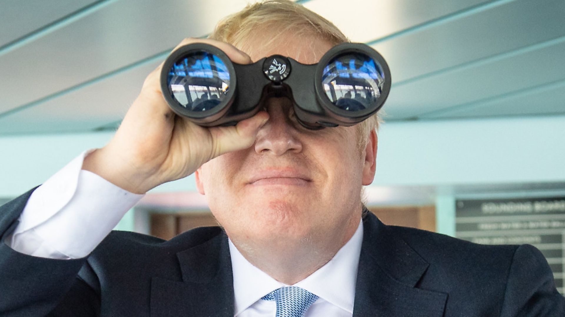 Boris Johnson uses a pair of binoculars on the bridge of the Isle of Wight ferry as it sets sail from Portsmouth. Photograph: Dominic Lipinski/PA. - Credit: PA