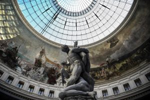 A picture taken on May 22, 2021 shows a partially-melted wax sculpture by Swiss artist Urs Fischer, depicting a replica of the marble sculpture by Italian artist Giambologna "The Rape of the Sabine Women", after its wick was lit at the Bourse de Commerce-Pinault Collection, which houses French billionaire Francois Pinault's private art collection in Paris.